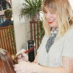 Color being applied to client's hair by hair dresser