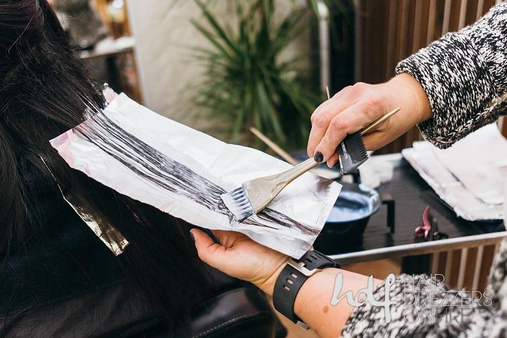 Hair color being applied to hair on a foil sheet