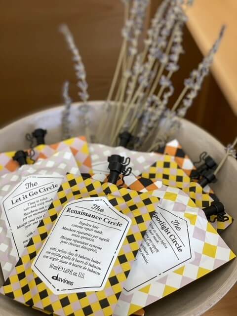 Davines hair products in a bowl with flowers